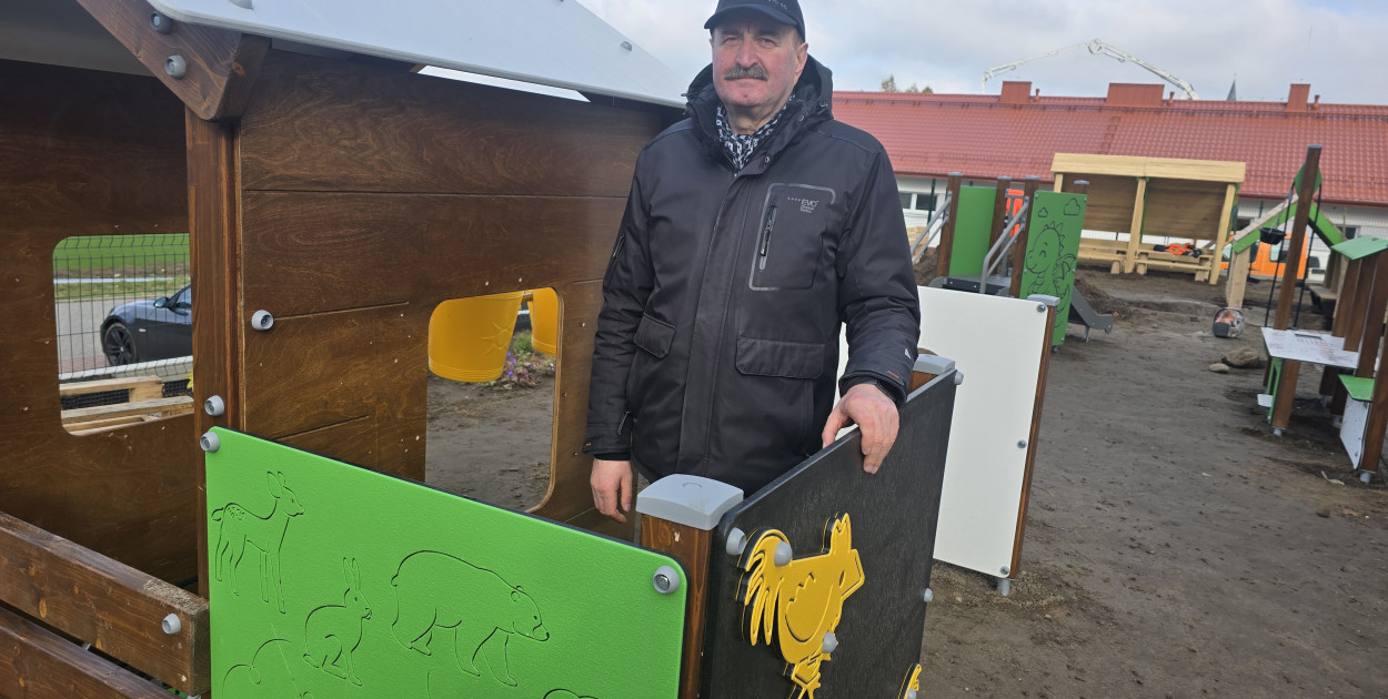 Wójt Jerzy Lewi Kiedrowski przy placu zabaw wykonanym z drewna rubinowego
